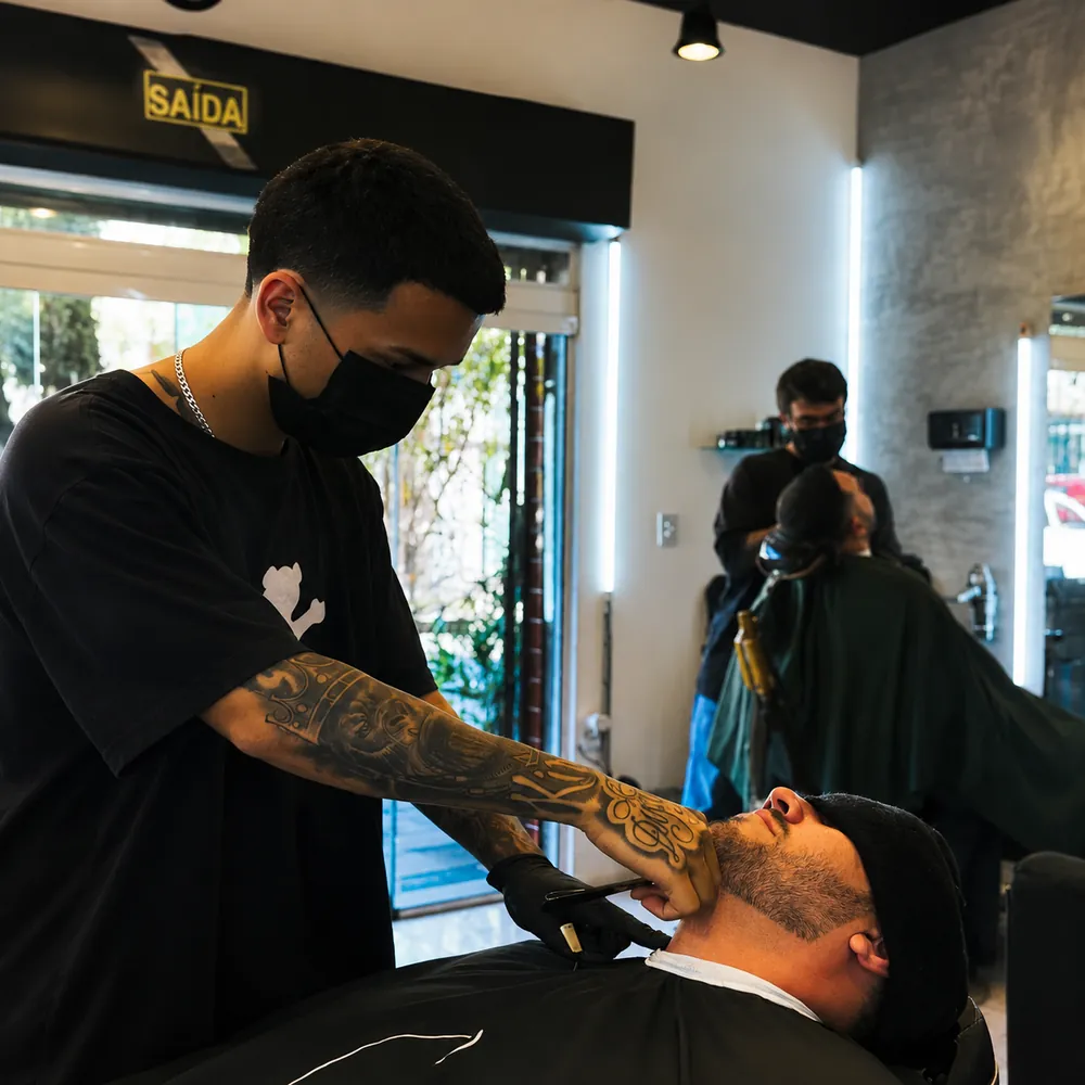 Barbeiro atendendo cliente na cadeira da Call Barber Shop
